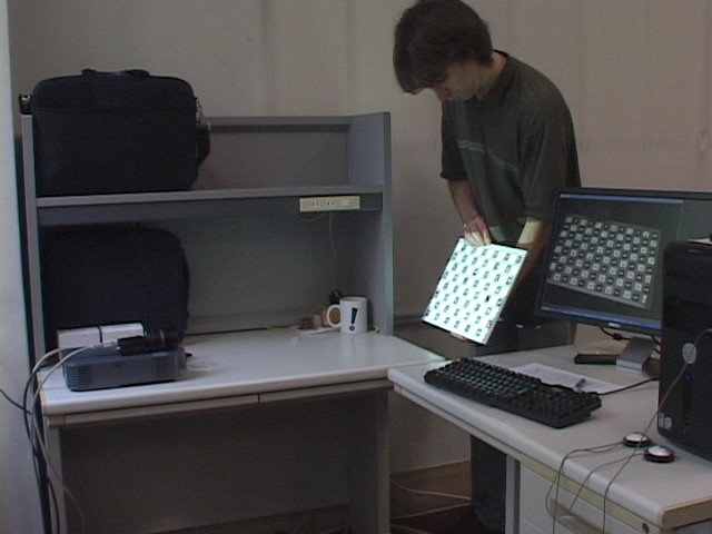 Snapshot of our demo video showing the test user calibrating a casually installed projector-camera system.